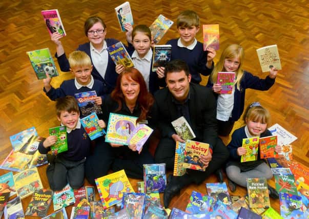 Ros Brunson and Craig Salvidge from Moto visited Hanging Heaton school to donate books and £500. They are with Maisy Swift / Devon Oldroyd / Stan Kilburn / Will Knight / Emily Bottomley / Samuel Wilson / Ruby Gott. (D532B422)
