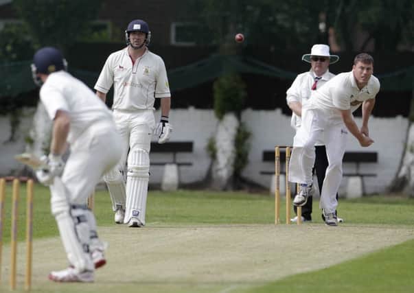 Hanging Heaton bowler Dan Busfield in action against East Bierley.