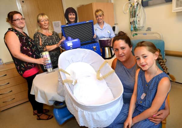 Amy Hart and Ella-May Brooke  delivering a 'cold cot' and a moses basket for Dewsbury Hospital, pictured with fundraisers Nichola Hinchliffe and Nikki Cookson and nurses Cathy McLean and Jody Bell. (d625a431)
