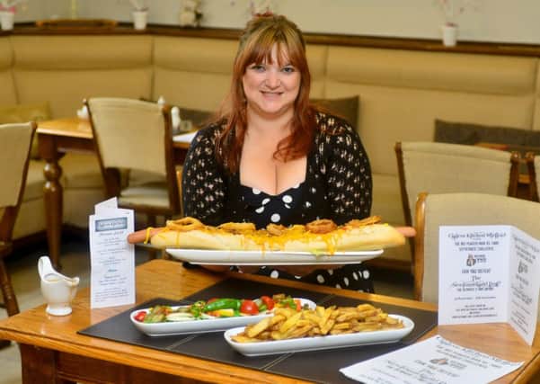 MIGHTY MEAL Claire Batley of Claire's Kitchen is challenging customers to eat this 2ft hotdog called the 'Newfoundland Dog'. (D512C436)