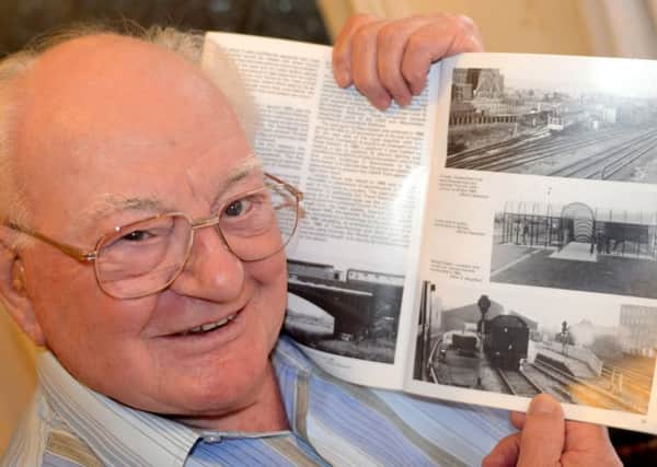 Former train worker Jack Mitchell with railway photographs. (d622a438)