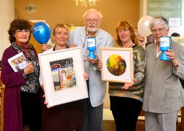 Artist Keith Smith presenting money raised to Parkinson's charity after selling his art at the Wellbeing Centre in Cleckheaton with Carol Swift , Sheron Parkin, Chrissie Fielden from Parkinsons UK and Imogen Smith. (D524F443)