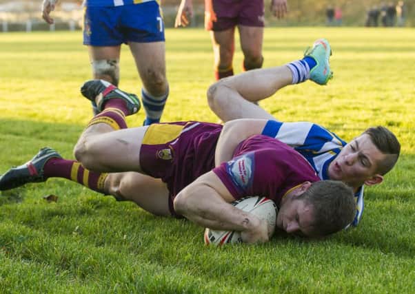 Andy Robinson holds off a Batley Boys defender to score before he is congratulated by Dewsbury Moor teammates in last Saturdays Pennine League derby win.