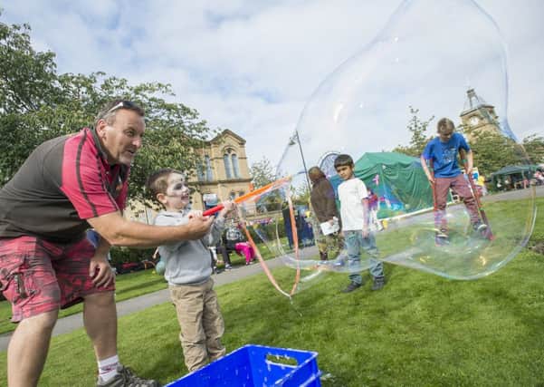 SEPTEMBER 2014 Andy Chataway, of Crafty Devilz, and Jack Watson, four, get the giant bubbles going at Batley Festival.