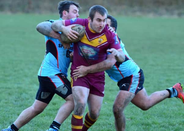 Peter Robinson is held by the Widnes West Bank defence during Dewsbury Moors impressive BARLA National Cup success.