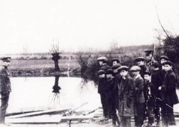 A group of soldiers from D Company, of the 4th Battalion, Kings Own Yorkshire Light Infantry, by the pond in Morton.