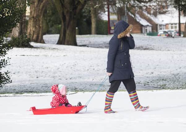 A girl pulls her young sister through the snow on a sled in Thornhill - but not everyone will enjoy the freezing conditions this weekend.