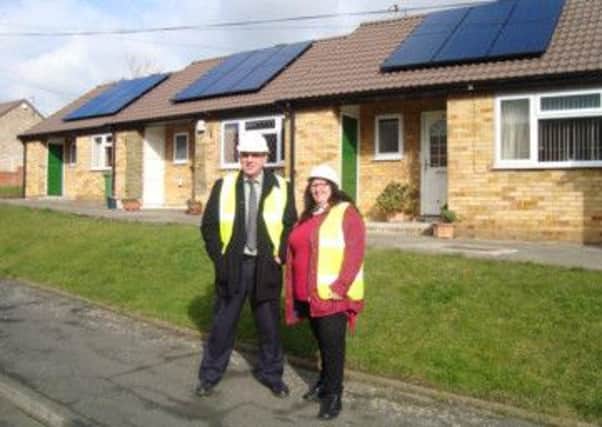 Councillors Cathy Scott and Andrew Cooper outside one of the houses.