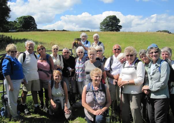Dewsbury and District Rambling Club members add a waymarker to the Centenary Walk route.