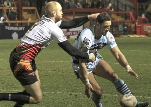 Dewsbury's Shane Grady challenges Featherstone's Paul Sykes as the Rovers player is about to put in a grubber kick. Picture: Bob Nunn.