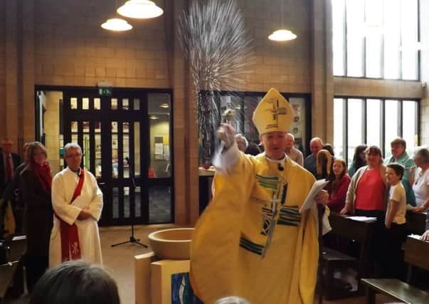Bishop Baines baptises the congregation  and the cameraman!