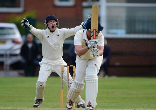Hanging Heaton wicketkeeper Joe Suggitt celebrates the wicket of Ian Wood.