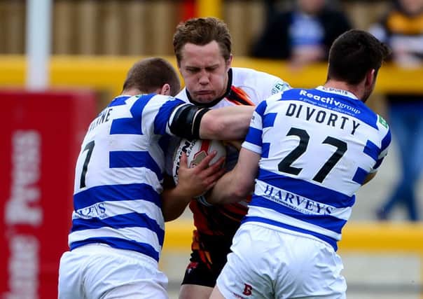 Dewsbury prop Ryan Hepworth is wrapped up by Halifax defenders Ben Johnston and Ross Divorty last Sunday.