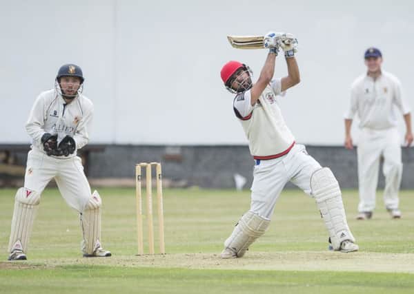 Mirfield Parish Cavaliers batsmen Salman Sayed hits out as Townville wicket keeper Liam Booth looks on.