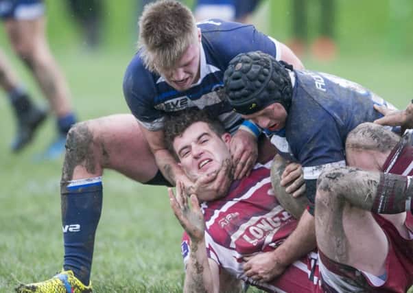 Thornhill's Joss Ratcliffe is wrestled to the floor by two Sharlston defenders in Saturday's Yorkshire Cup clash.