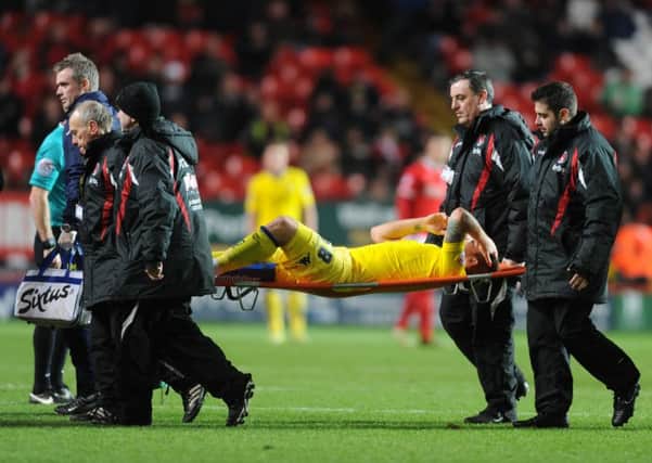 Leeds United's Gaetano Berardi is stretchered off the pitch at Charlton and now looks to be out for two months.