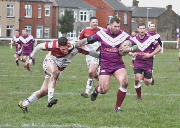 Shane Davies hands off a Wibsey defender during Thornhill Trojans A team's cup win.