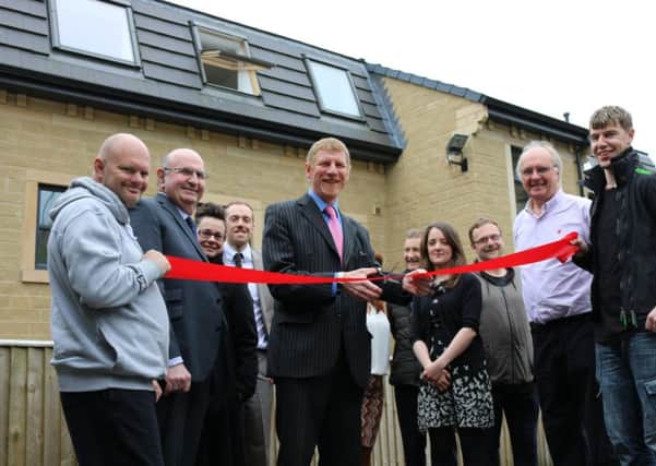 Councillor Martyn Bolt (centre) cuts the ribbon to the opening of Bankview living apartments in Mirfield.