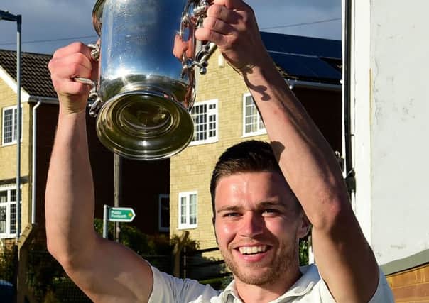 Ossett captain Charles Orme lifts the Jack Hampshire Cup.