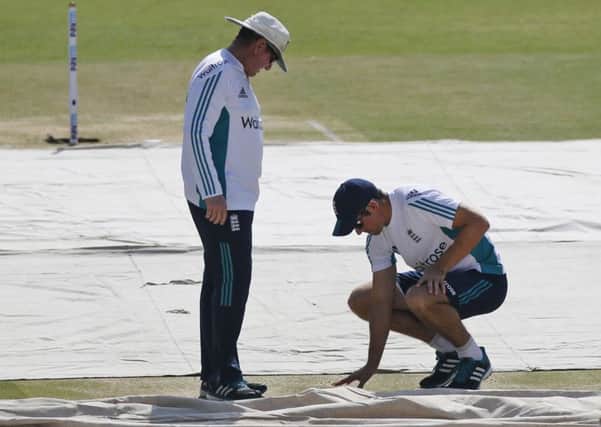 England's cricket captain Alastair Cook, right , inspects the pitch with head coach Trevor Bayliss during a practice session ahead of their first Test in Rajkot. Picture: AP/Rafiq Maqbool