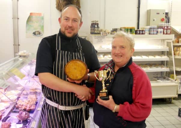 PIE HIGH: Janet Sheard, a fieldsperson for Craven Cattle Marts, presents the pork pie trophy to George Haigh of Haighs Farm Shop.