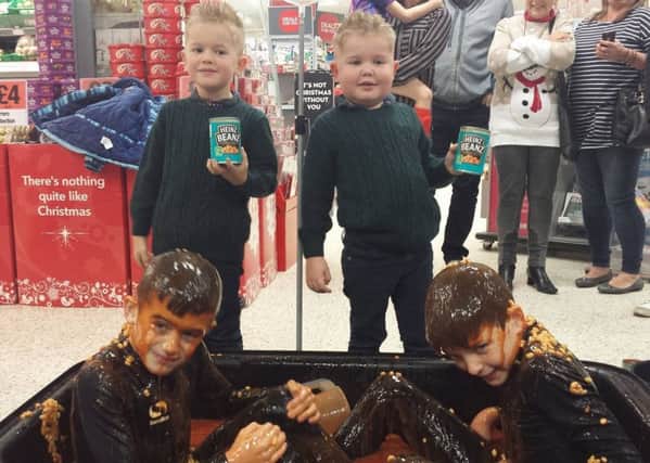 Zack , on the right,  and Leo, five, pour baked beans on Tyler and Ben, nine.