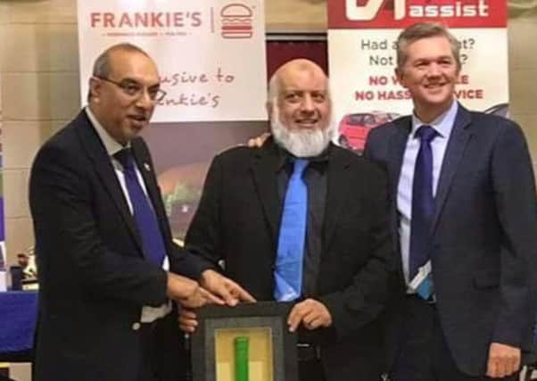 Hanif Mayet and Abdul A Ravat receiving the engraved bat from Mark Arthur. The bat is to commemorate the match at Headingley and signed by all of St Peter's cricket team and committee.