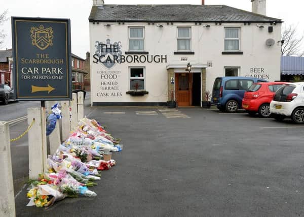 Flowers and tributes are laid by the car park to The Scarborough pub in Thornhill, Dewsbury, after the death of a man over the weekend.