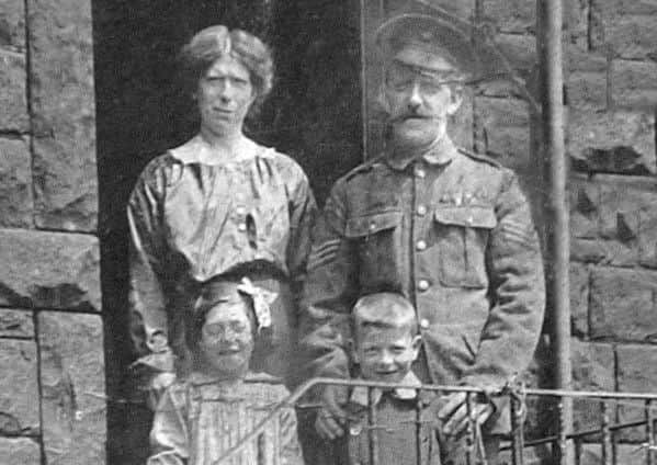 FAMILY MAN: Sergeant Ormsby is pictured outside his house on Victoria Road, Springfield, with wife Catherine and two children.