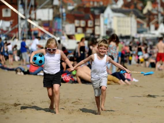 Madeleine and Bailey Doherty enjoy the beach as crowds pack onto the South Bay in Scarborough as warm weather bathed the UK at the weekend.