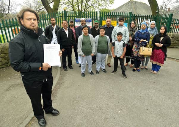 Holding a petition signed by over 200 parents is Khalid Patel. Picture ref: AB0102a0417
