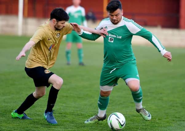 St John Fisher striker Rob Bordman attempts to take on a Linthwaite defender during the Heavy Woollen Challenge Cup final