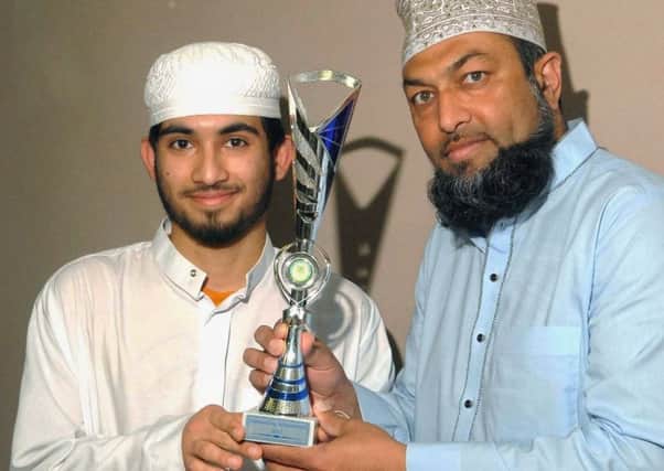 Student Basim Khajwal is presented with his trophy by Mosque leader Afroz Ashrafi.