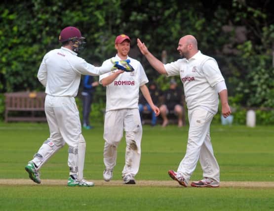 Chris Brice is congratulated by wicketkeeper Greg Finn after taking the big wicket of Lee Goddard on his way to  claiming 2-4 from 10 overs as Woodlands sent holders New Farnley crashing out of the Heavy Woollen Cup last Sunday. Picture: Steve Riding