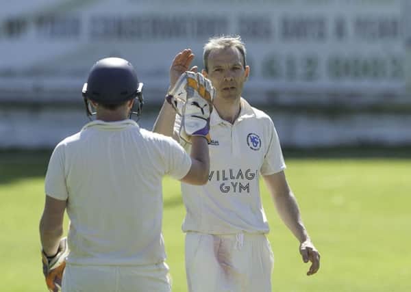 Heckmondwike & Carlinghow's Dave Pickett celebrates taking a wicket against Sandal.
