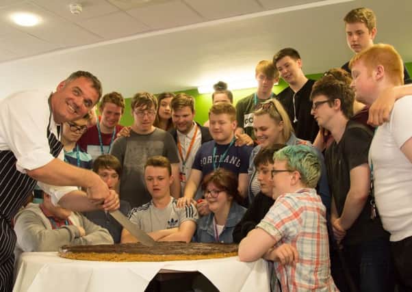 TAKING THE BISCUIT: Hospitality and catering students with the giant millionaires shortbread.