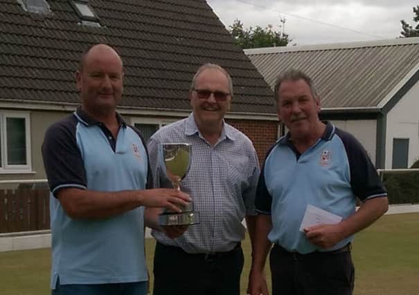 S Wainwright and A Mitchell recieve the Heavy WOollen Park pairs trophy from secretary P Robinson.
