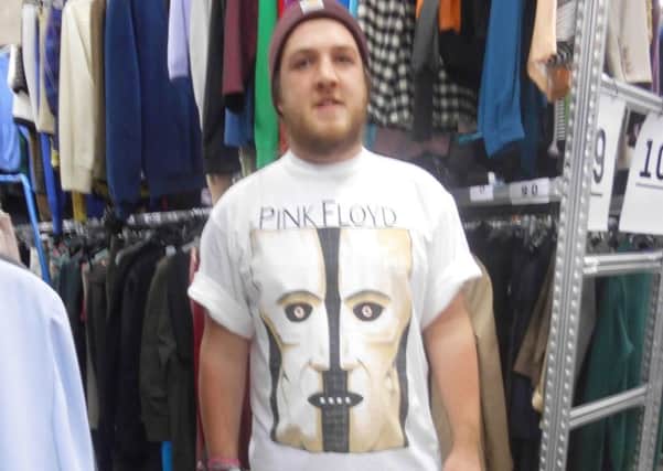 A model tries on the rare 1994 Pink Floyd Tour t-shirt at Oxfam's Festival Shop in Batley