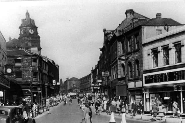 Bustling area: This Dewsbury town centre photograph shows the Fifty Shilling tailors on the right, along with Marks and Spencer and Woolworths.