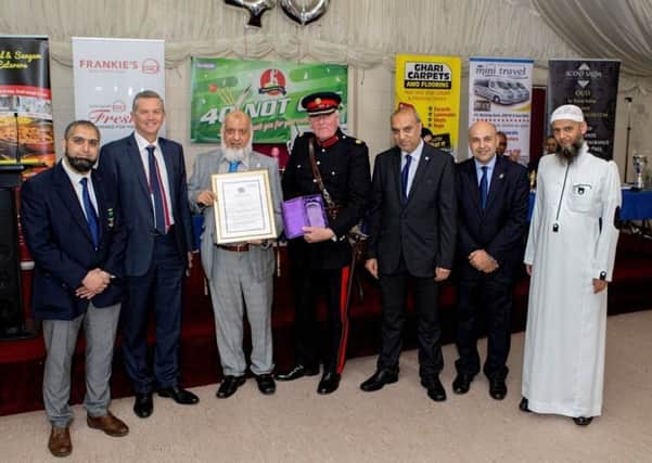 AWARD: Tim Hare Vice Lord-Lieutenant presents the Queens Award to Hanif Mayet, chairman of the club.