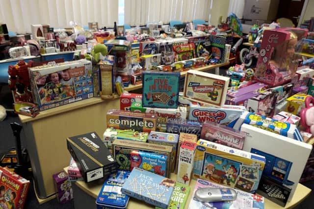 INUNDATED: The piles of games and gifts collected for the toy store.