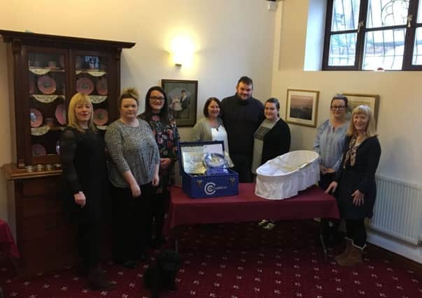Presented: Darryl and Tanya with the cuddle cot at George Brook Ltd donated in Elsie-Mays memory
