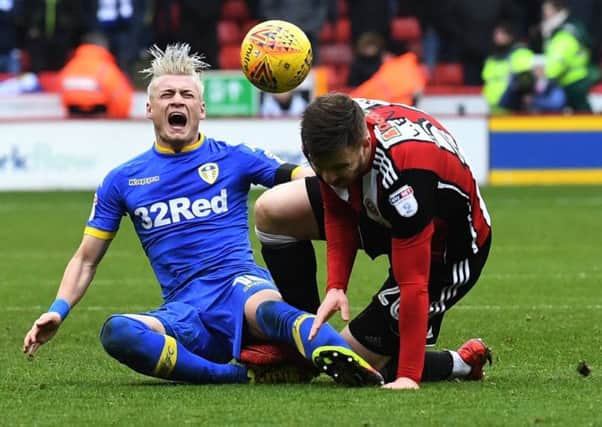 Leeds United's Gianni Alioski feels the pain after being fouled by Sheffield United's Lee Evans. Picture: Jonathan Gawthorpe