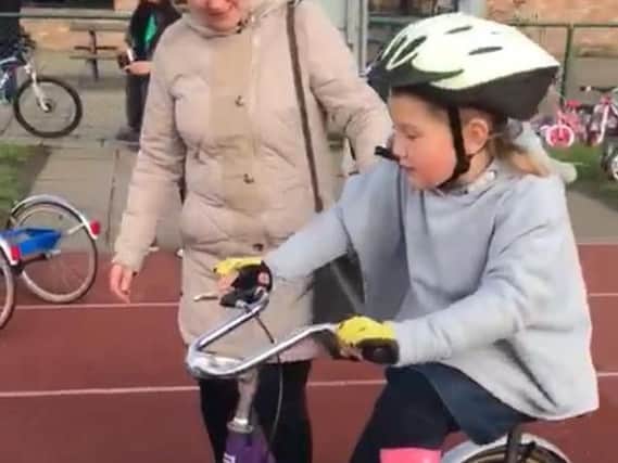 Eight-year-old Maisie Catt rides her specially-designed bike for the first time.