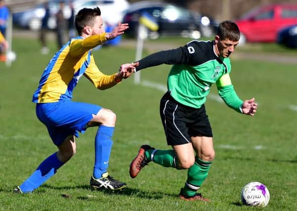 Chickenley's Timmy Clarke attemnpts to get away from Mirfield Town's Stephen Brown during the Heavy Woollen Sunday League Premier Division clash.