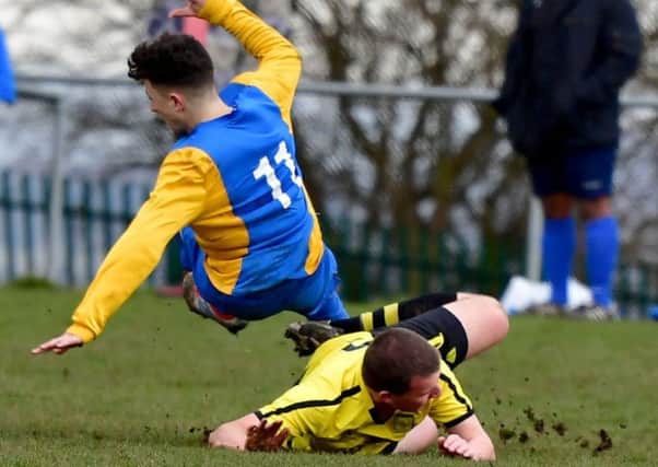 Roberttown's Nathan Willoughby produces a strong tackle on Mirfield Town's Kyle Walton during Sunday's Heavy Woollen Challenge Cup semi-final.